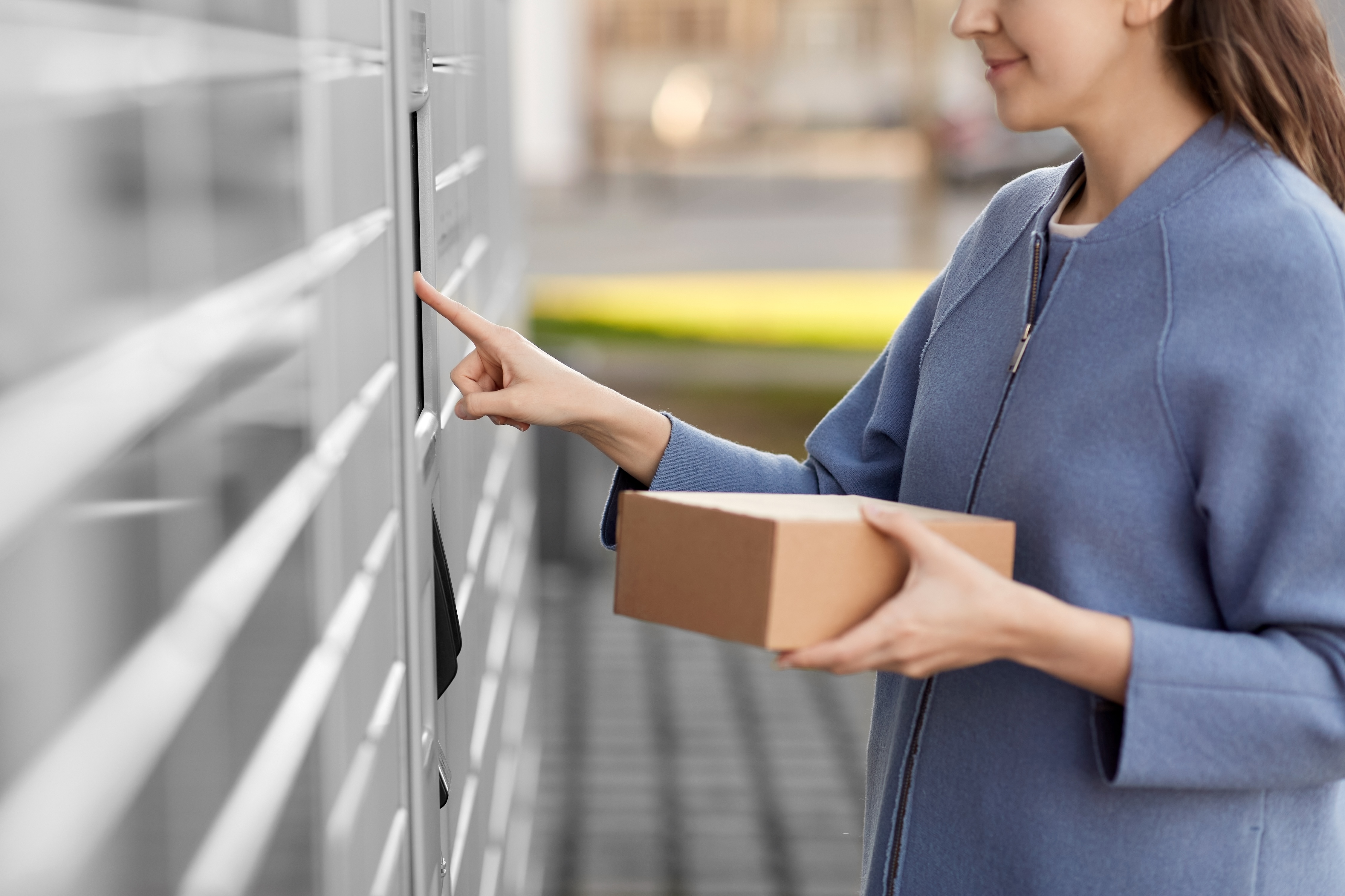 Woman getting package out of locker stock image