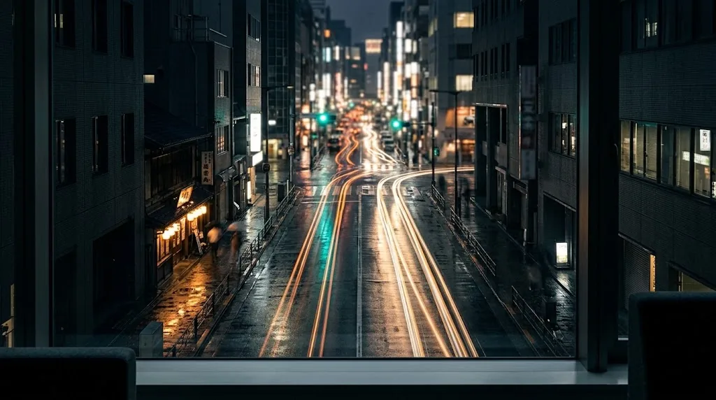Rain-washed Tokyo business street at night with warm light trails flowing toward a glowing intersection