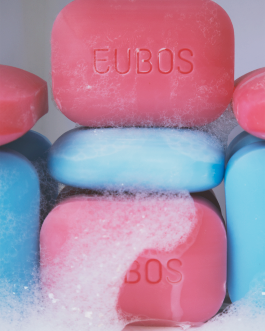 Close-up of stacked Eubos soap bars covered in soap foam bubbles.