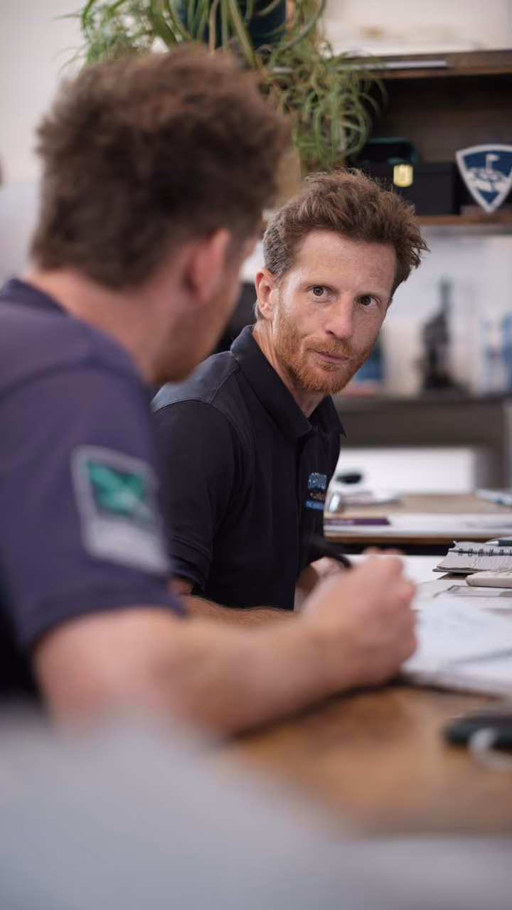 Two people in conversation across a table during a garden project consultation
