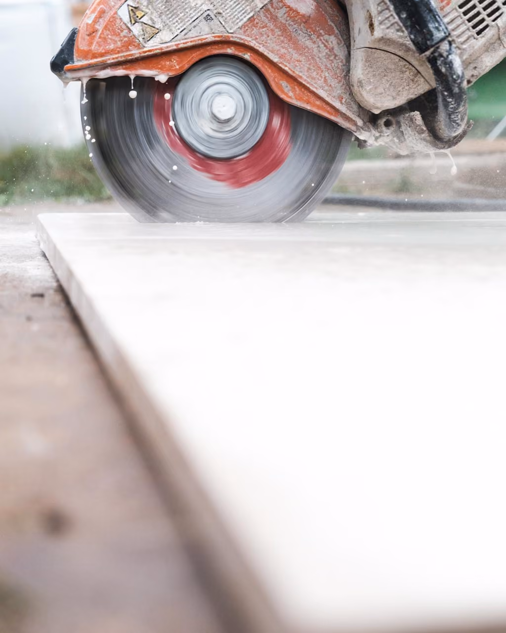 Circular saw cutting a stone slab with water suppressing the dust