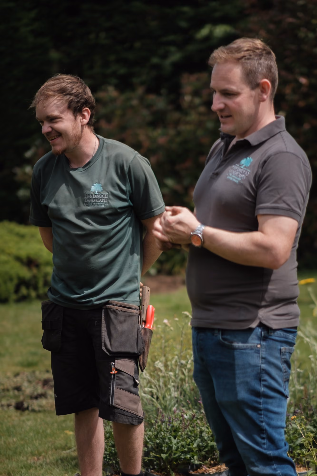 Two Hardwood Landscapes gardeners talking on site in branded uniform