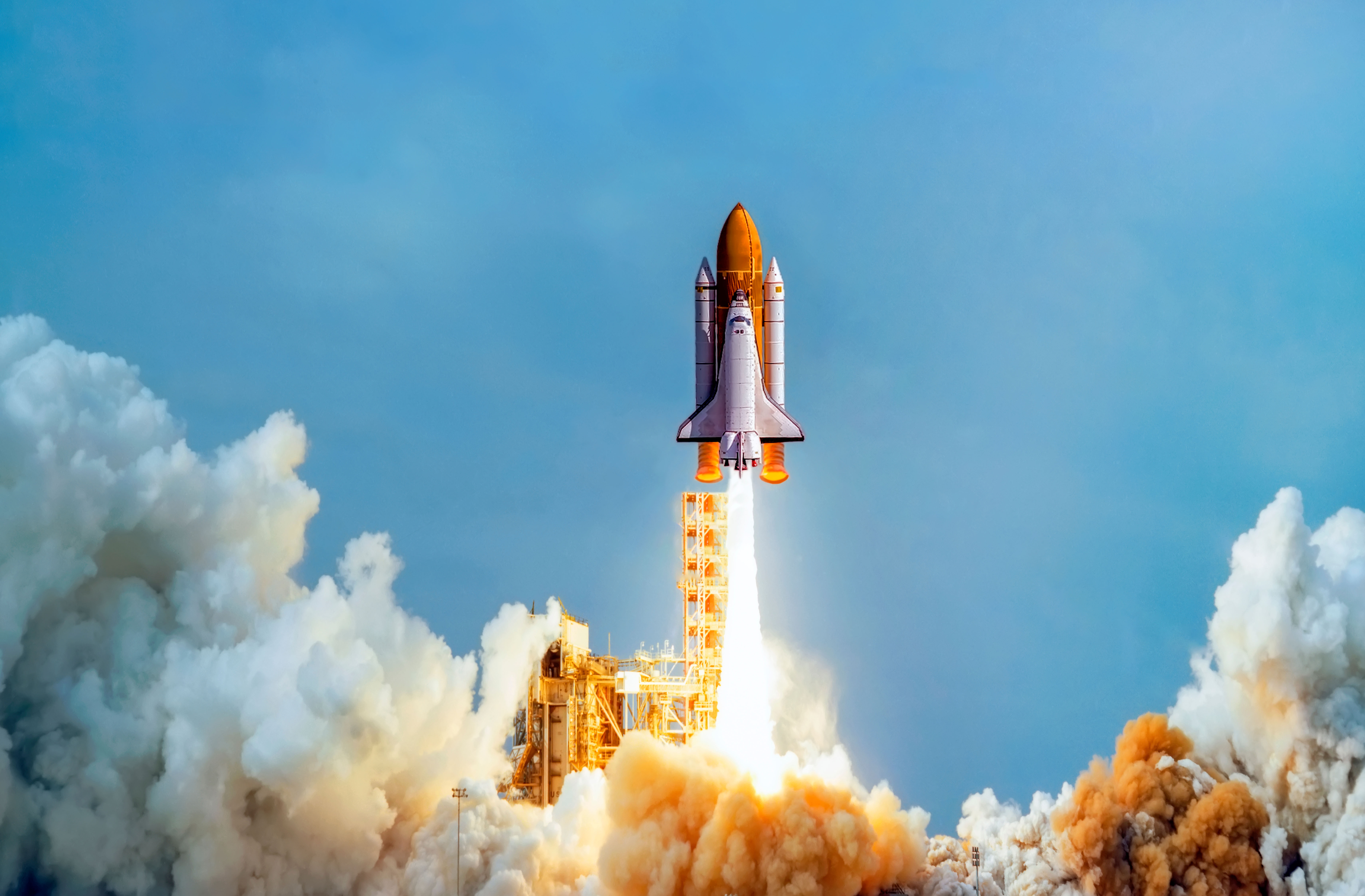 A space shuttle lifting off, engines and boosters at full thrust