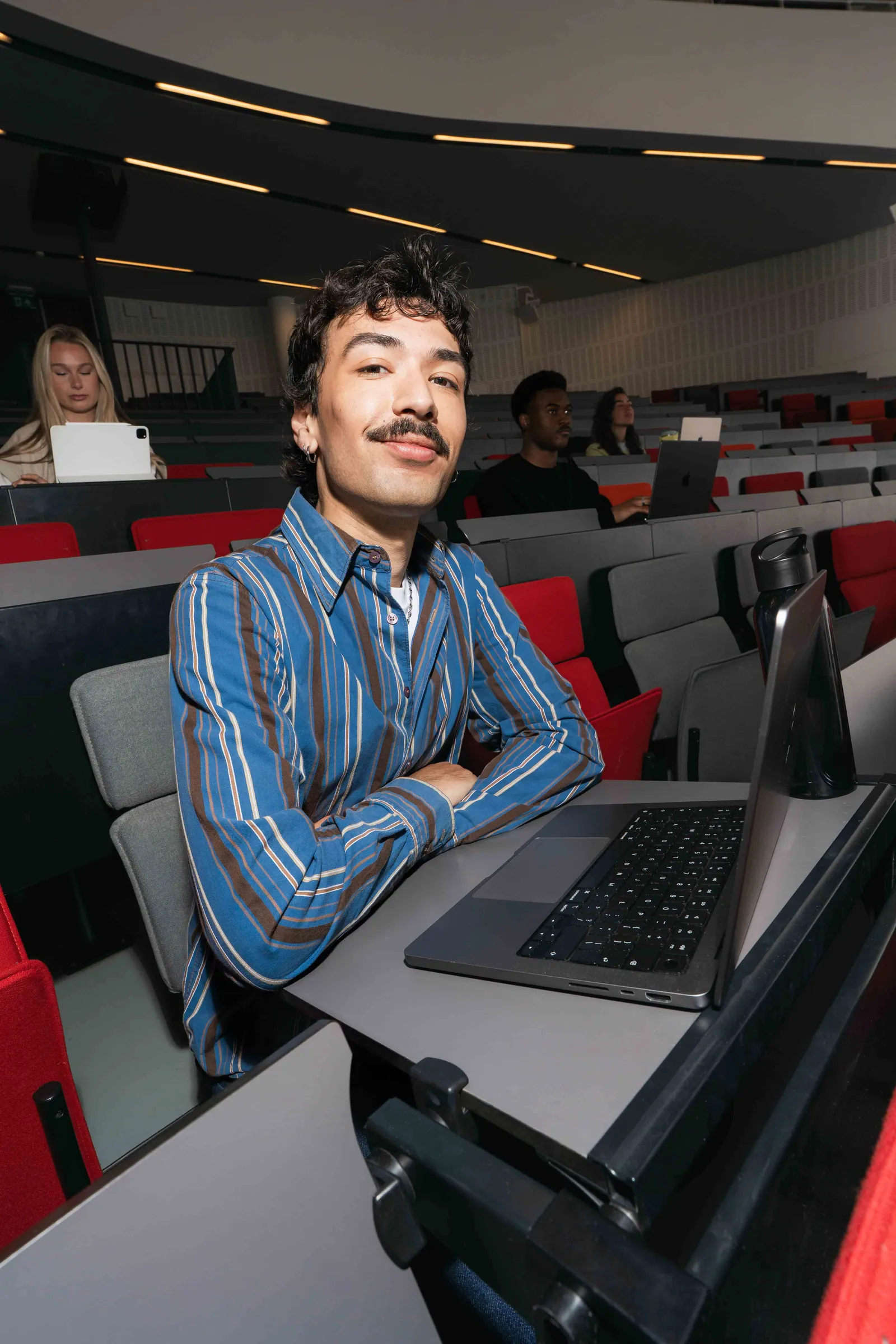 Student werkt op een laptop in een collegezaal