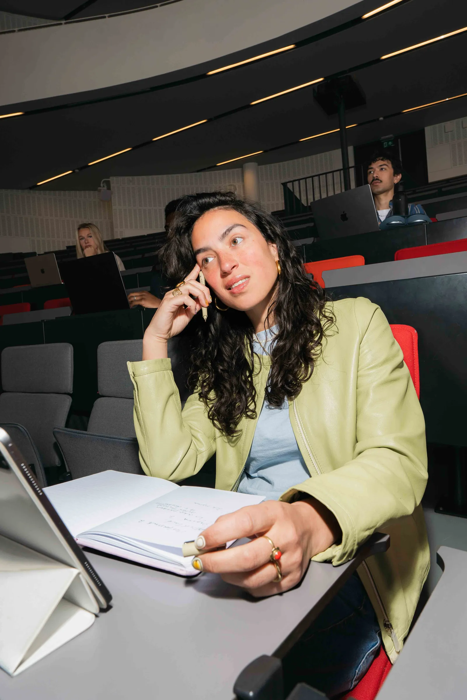Studente met notitieblok in een collegezaal