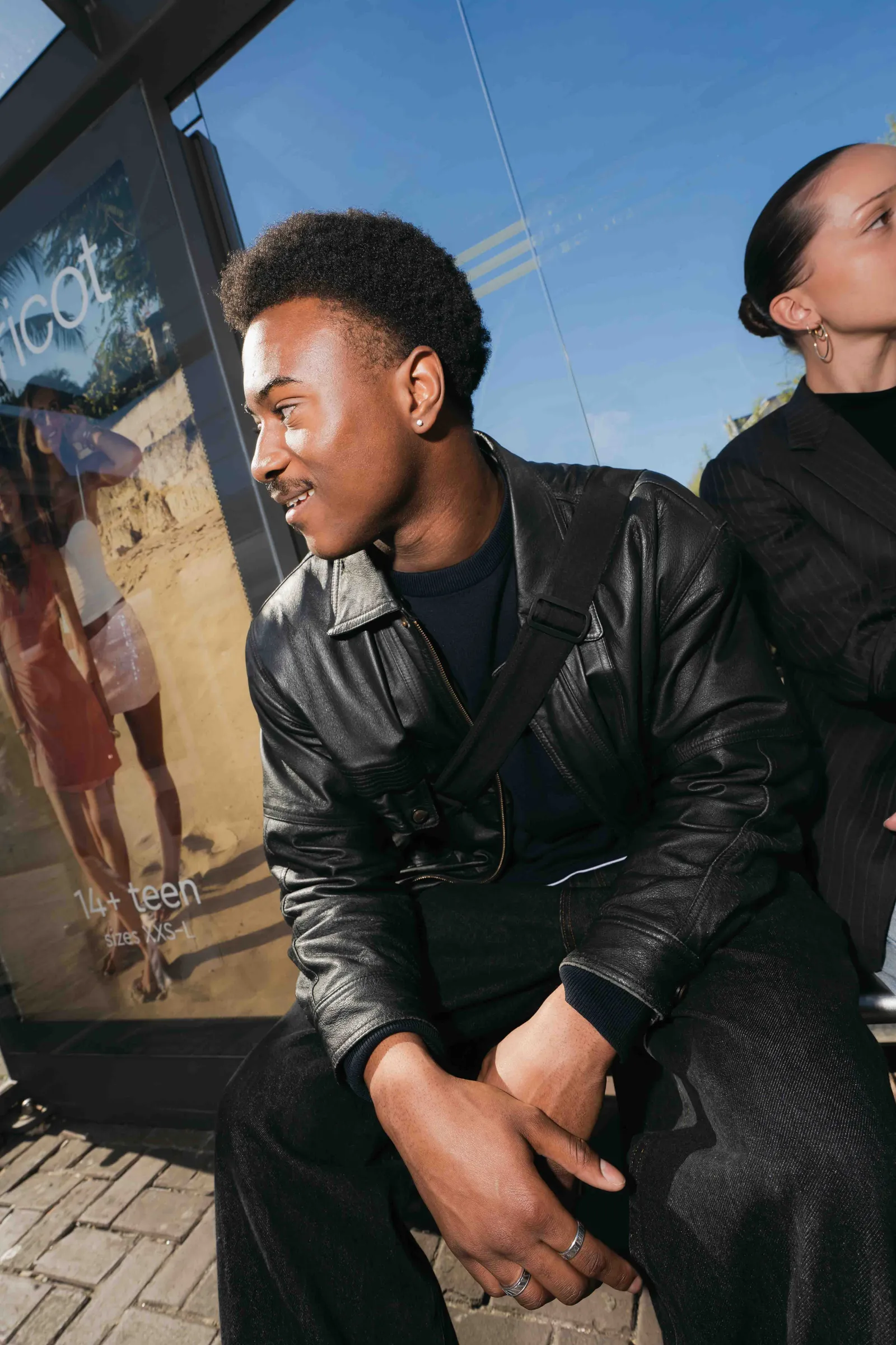 Lachende student in leren jas in de stad