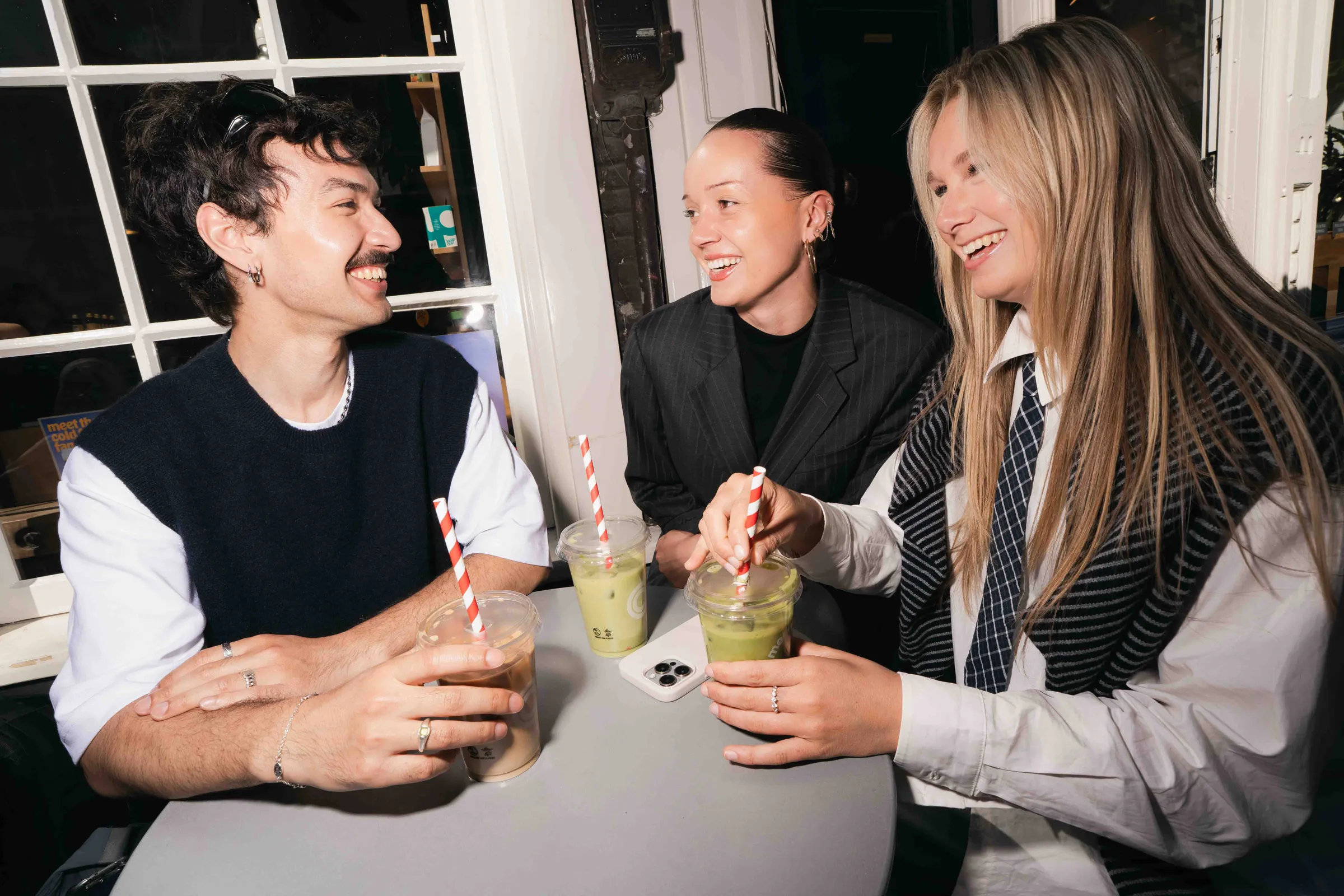 Drie studenten in gesprek aan een tafel