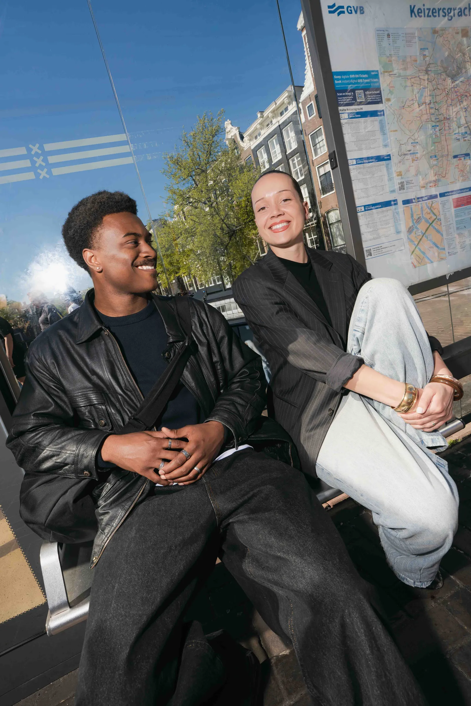 Twee lachende studenten op een bankje in de stad