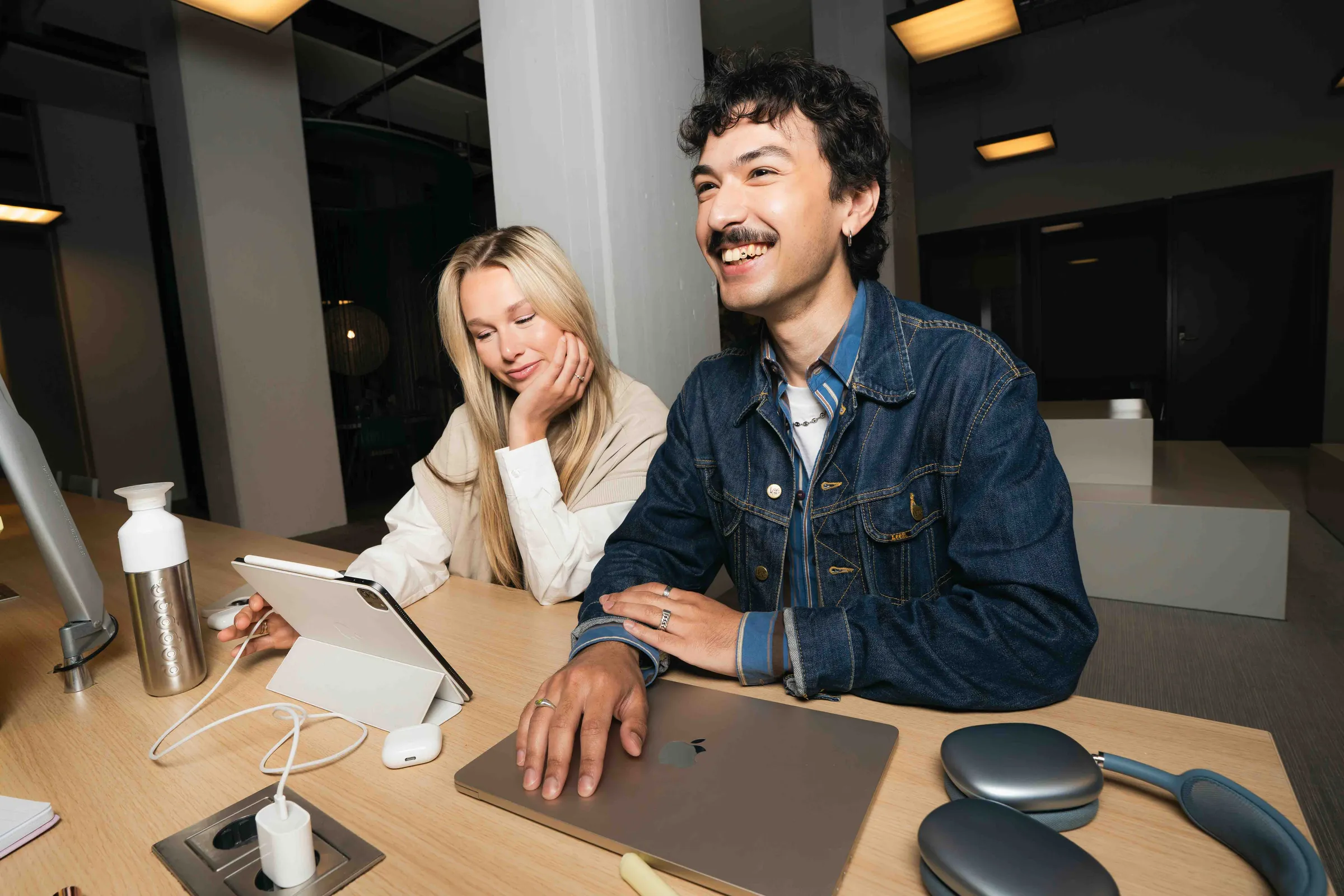 Twee collega's werken samen aan een laptop