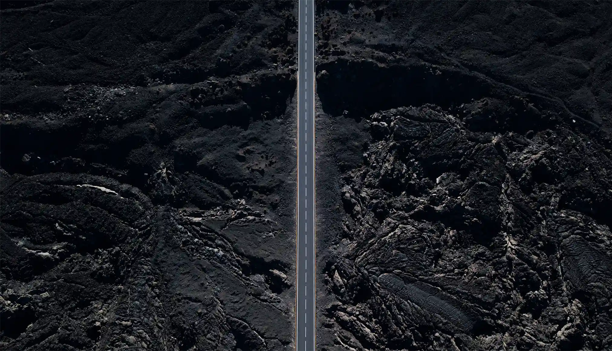 Aerial shot of a volcanic landscape with a road through the middle