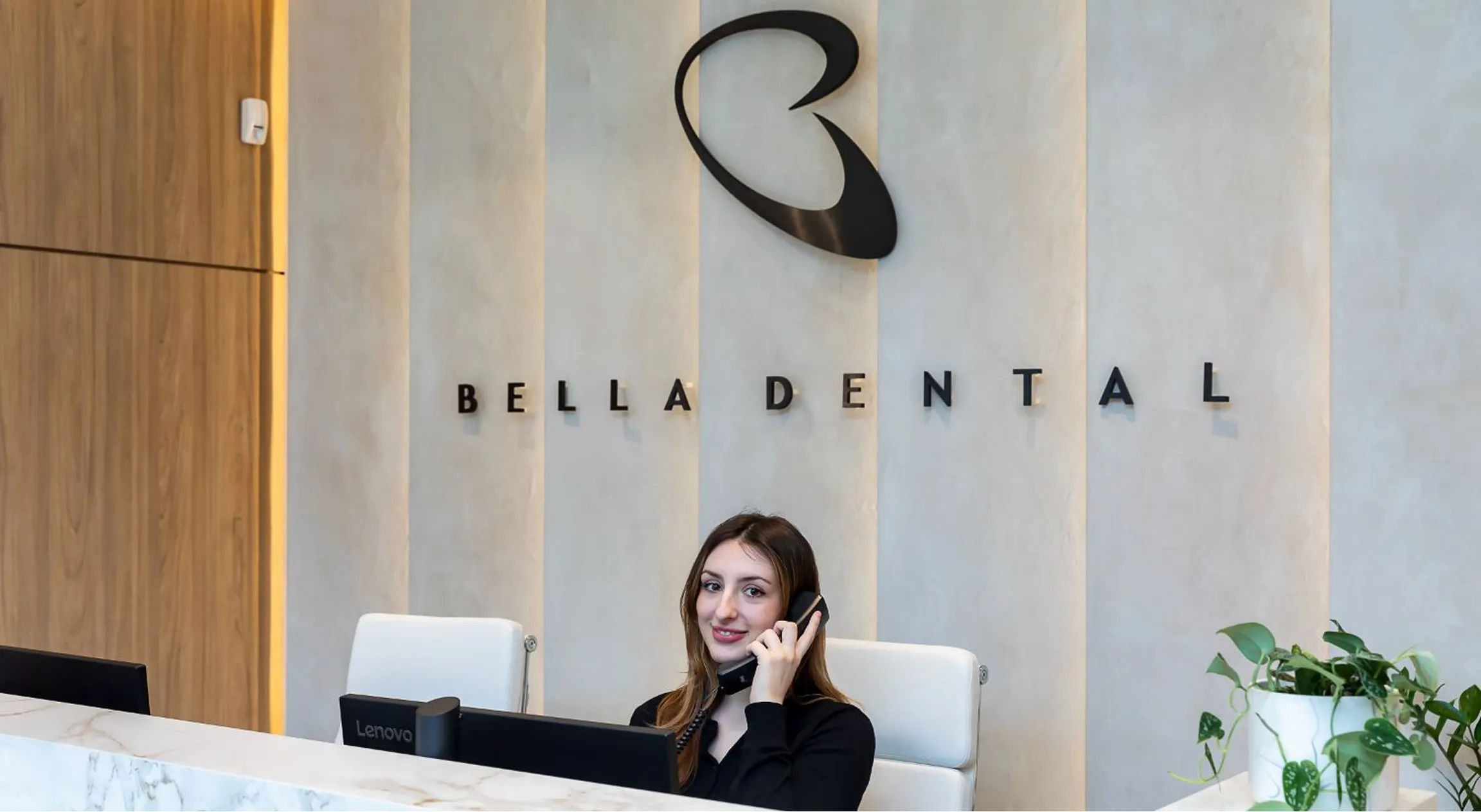 Bella Dental receptionist answering the phone at the front desk