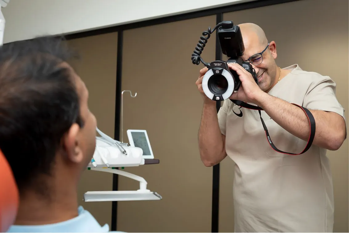 Dentist photographing a patient's teeth with a ring-flash dental camera