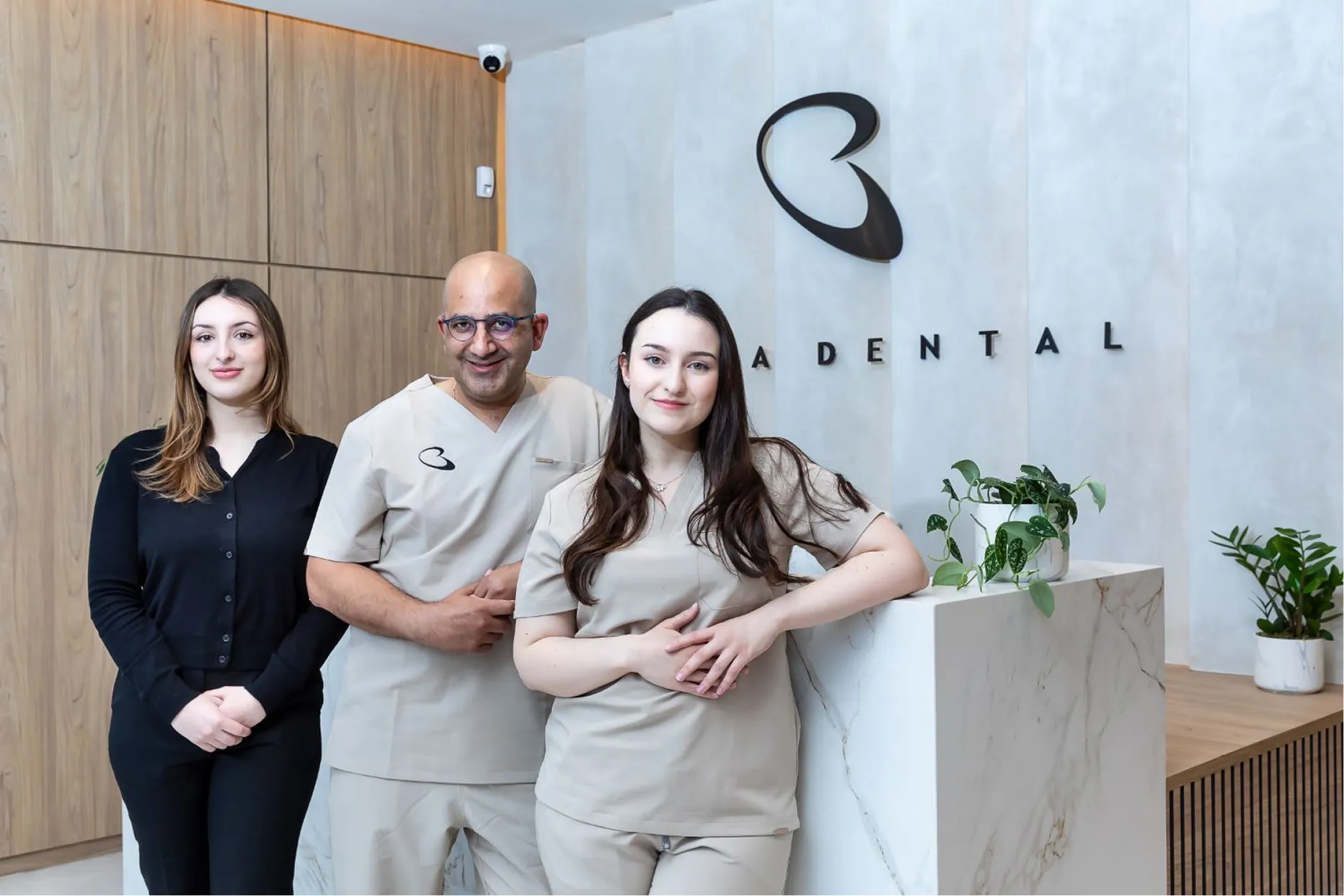 Bella Dental team of three standing together by the reception desk