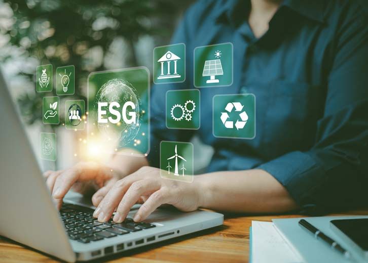 Hands on a laptop keyboard with ESG icons overlaid