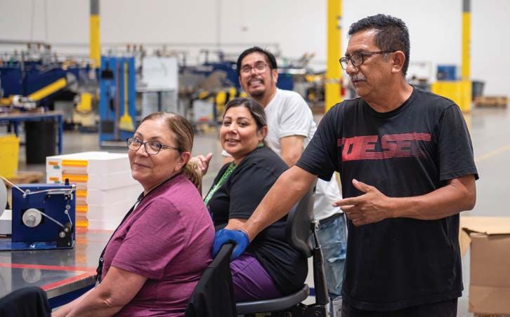 Truvant team members gathered around a workstation on the production floor