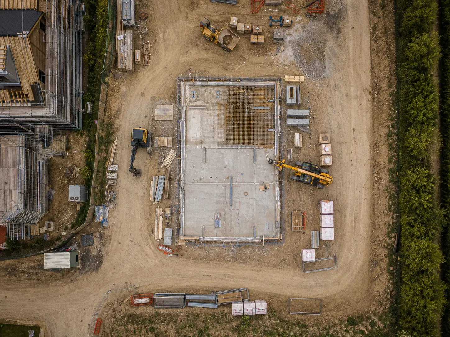 Aerial view of a building slab and site compound during groundworks