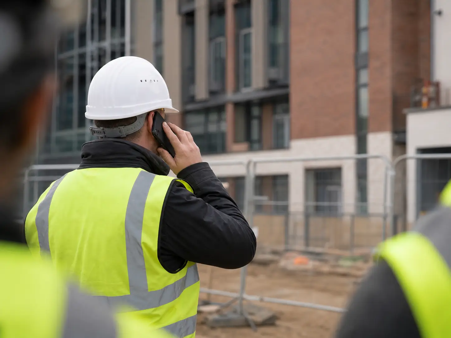 Site manager on the phone outside a new commercial building