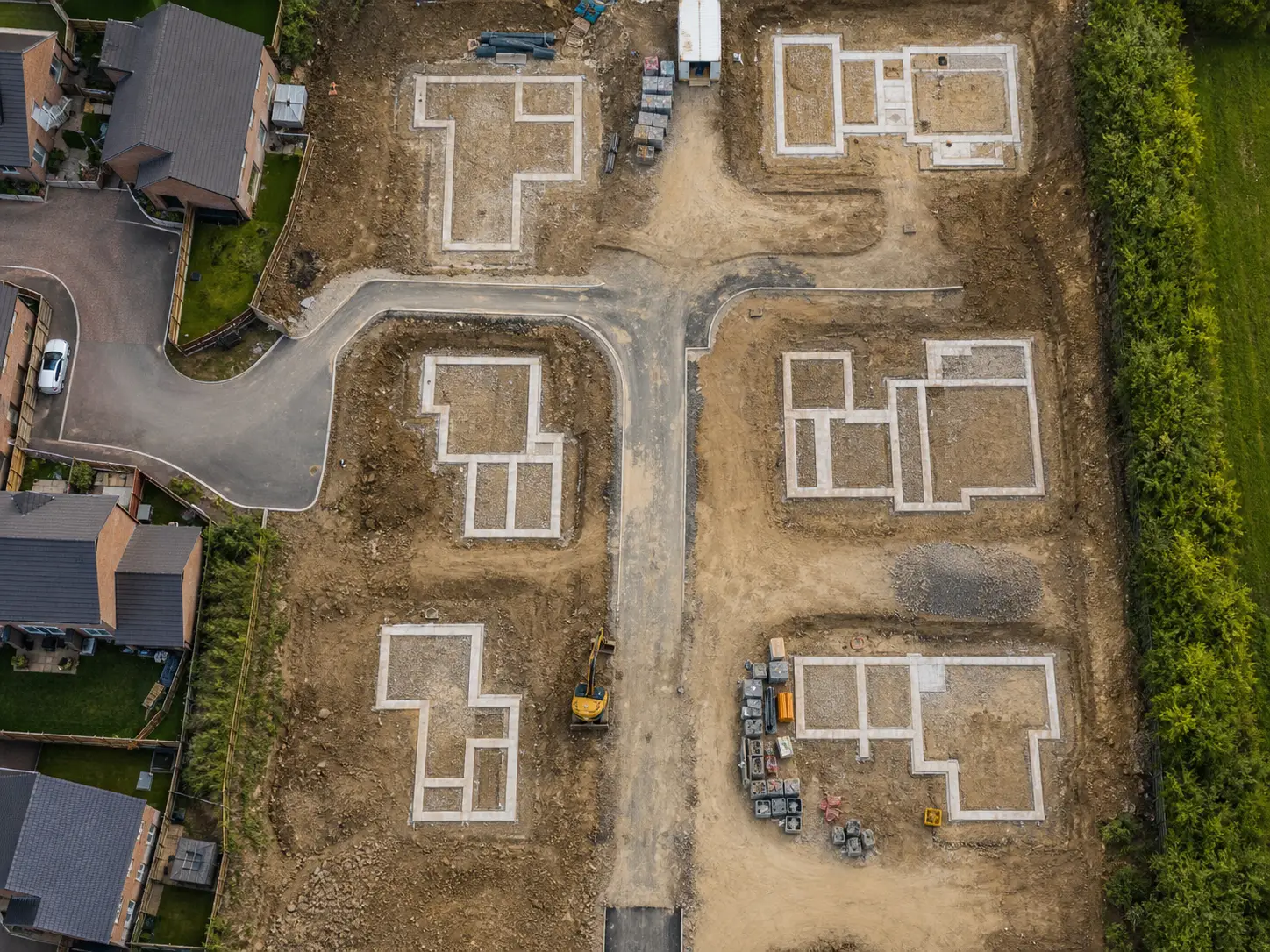 Aerial view of house foundations and a new estate road