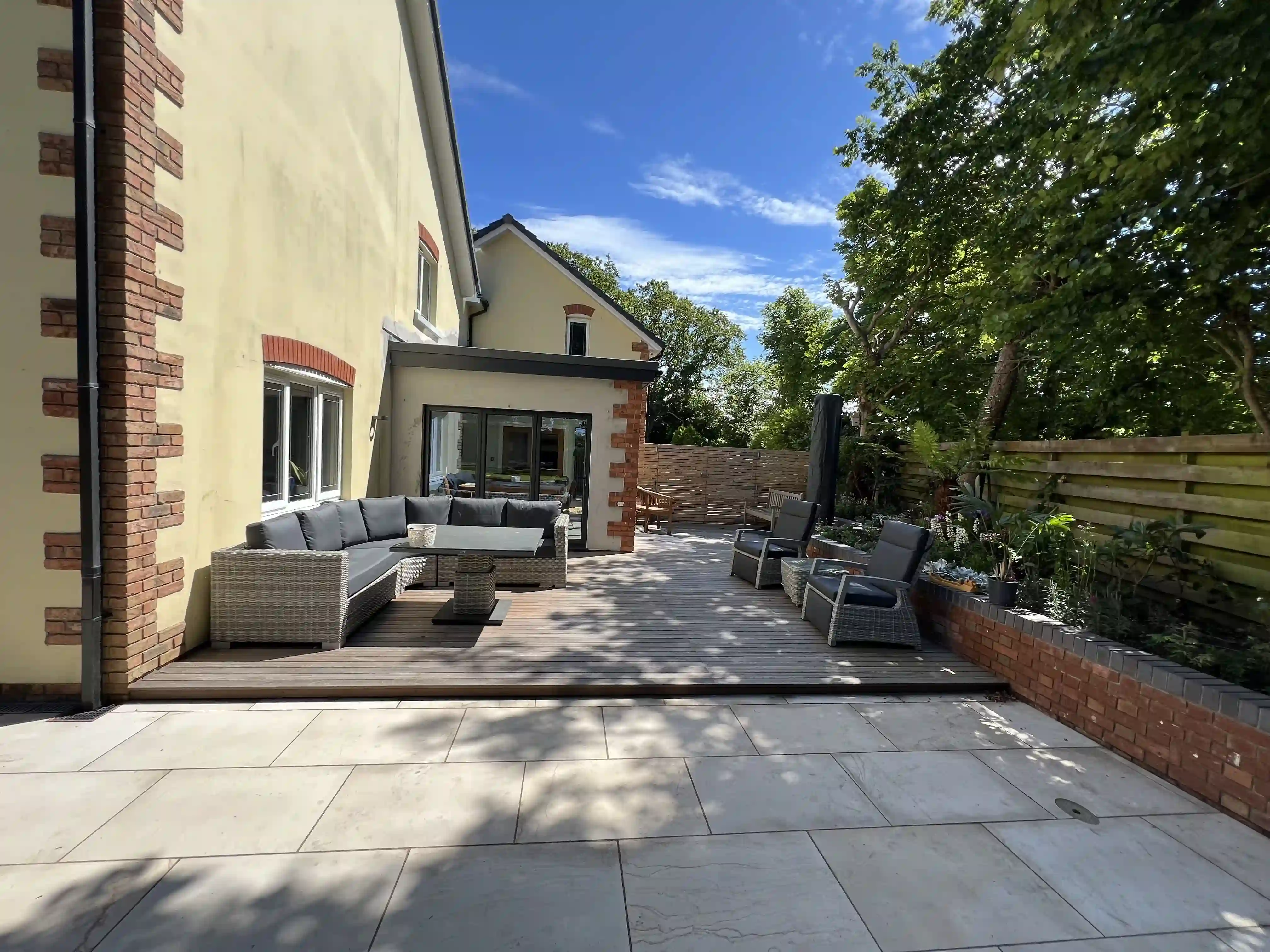 Porcelain patio with outdoor seating beside the new sunroom extension at 15 The Links, Peel