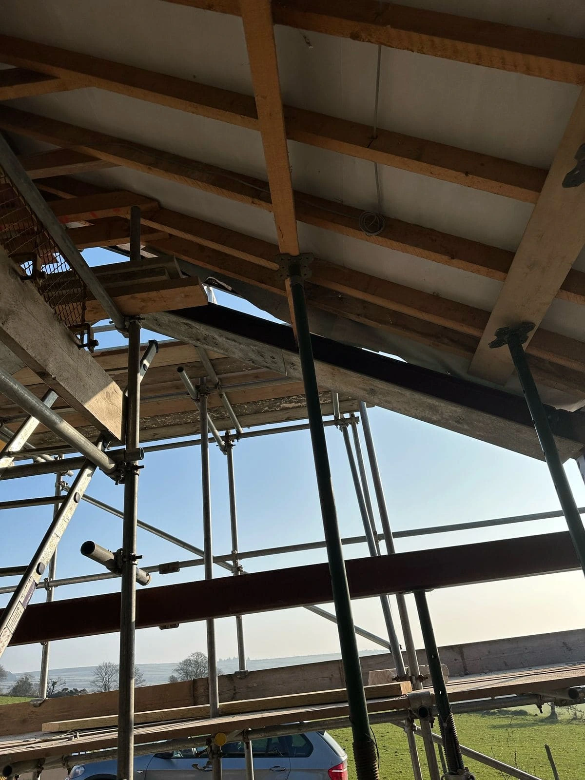 Exposed roof timbers and steel supports during structural strengthening at Ballamillighyn Cottage, Laxey