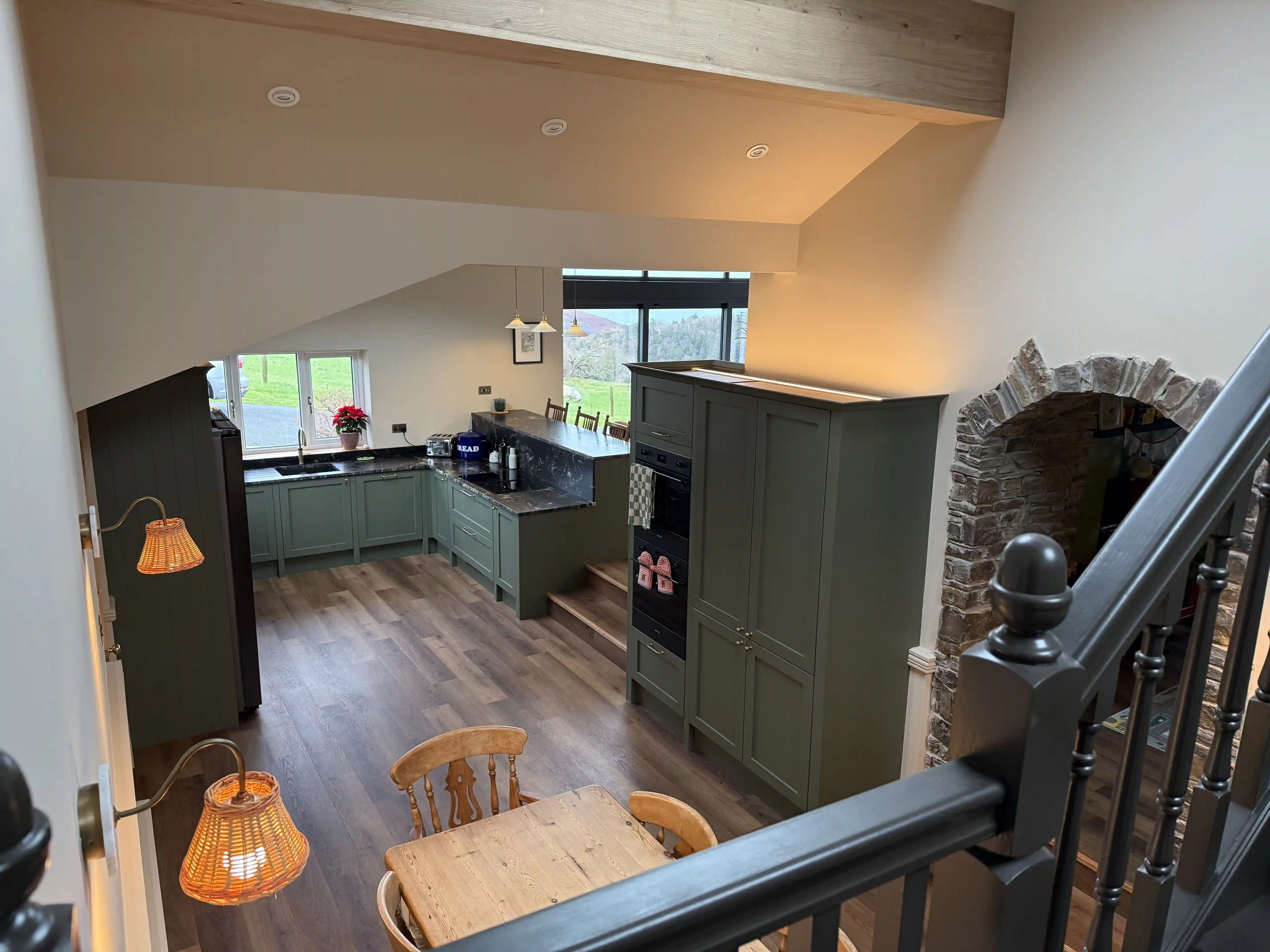 Kitchen and dining area seen from the mezzanine at Ballamillighyn Cottage, Laxey