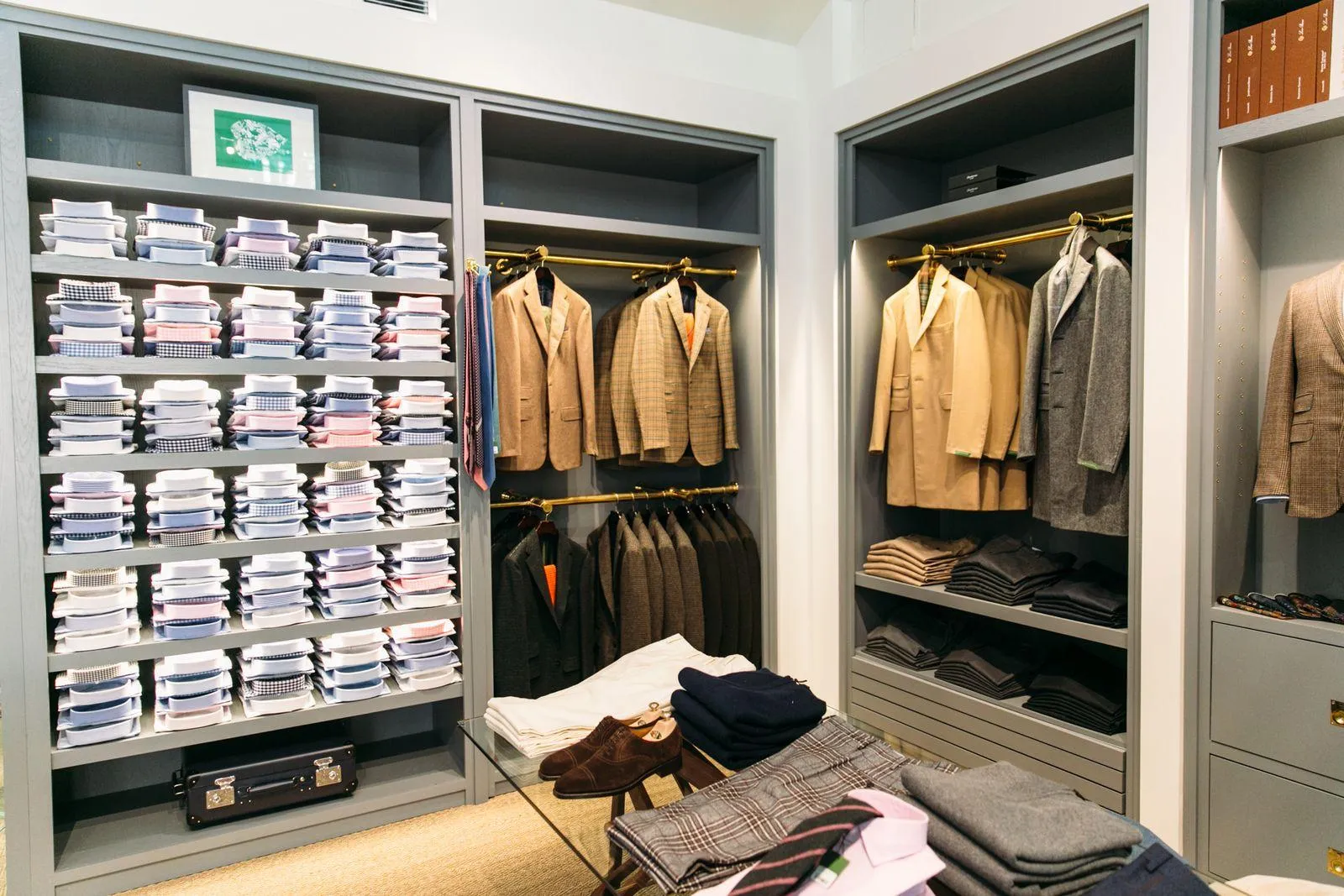 Eleganter Herrenausstattungsladen mit ordentlich gefalteten Hemden, Anzügen, Pullovern und Schuhen.