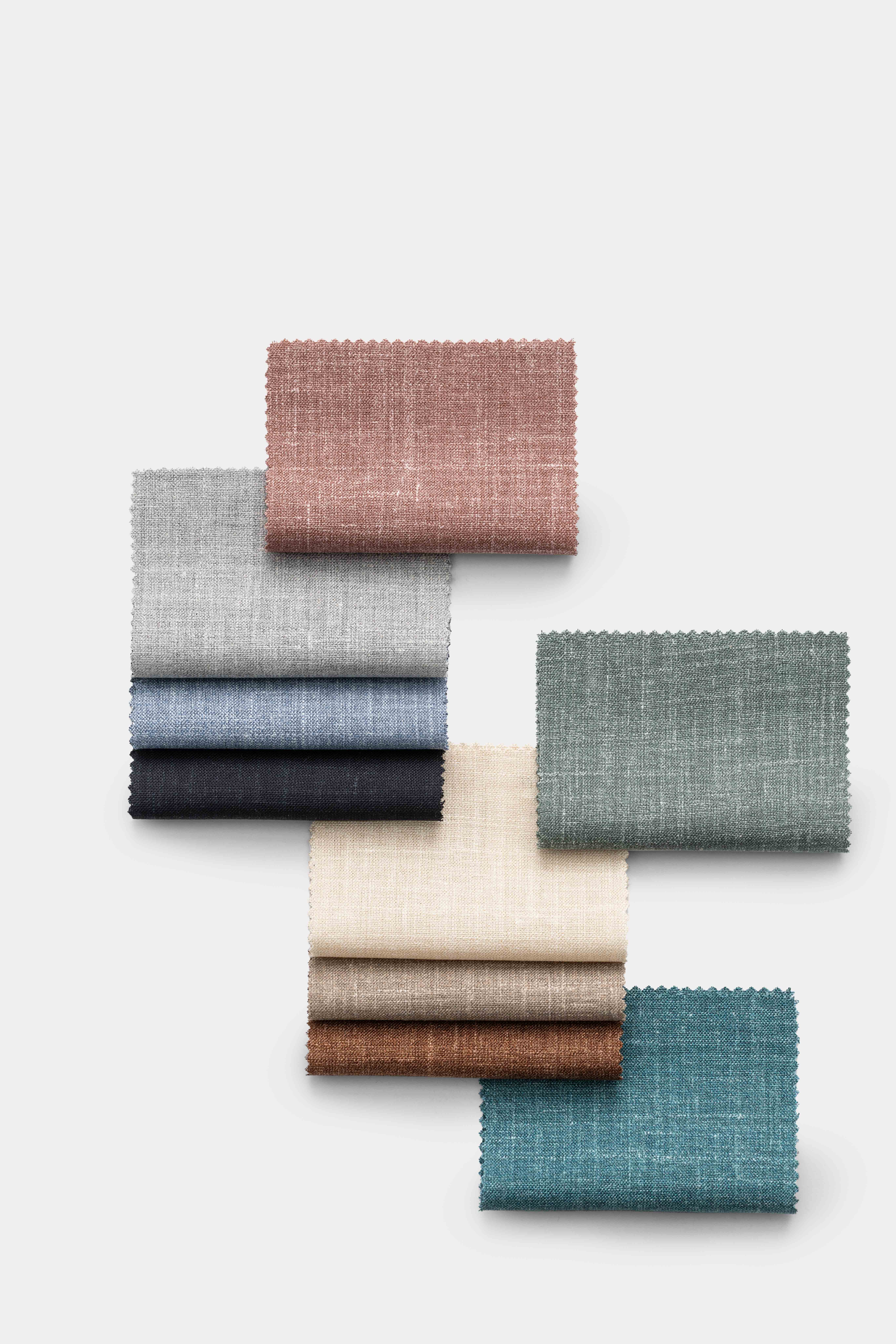 Mehrere Stoffmuster in verschiedenen Farben, darunter rosa, grau, blau, schwarz, beige, braun und türkis.
