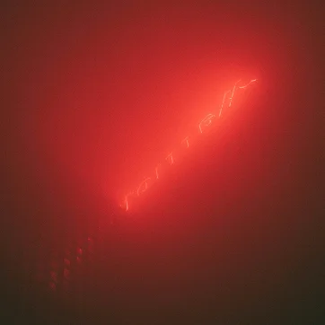 Abstract red neon light glowing through a dark, hazy background with a diagonal streak of light.