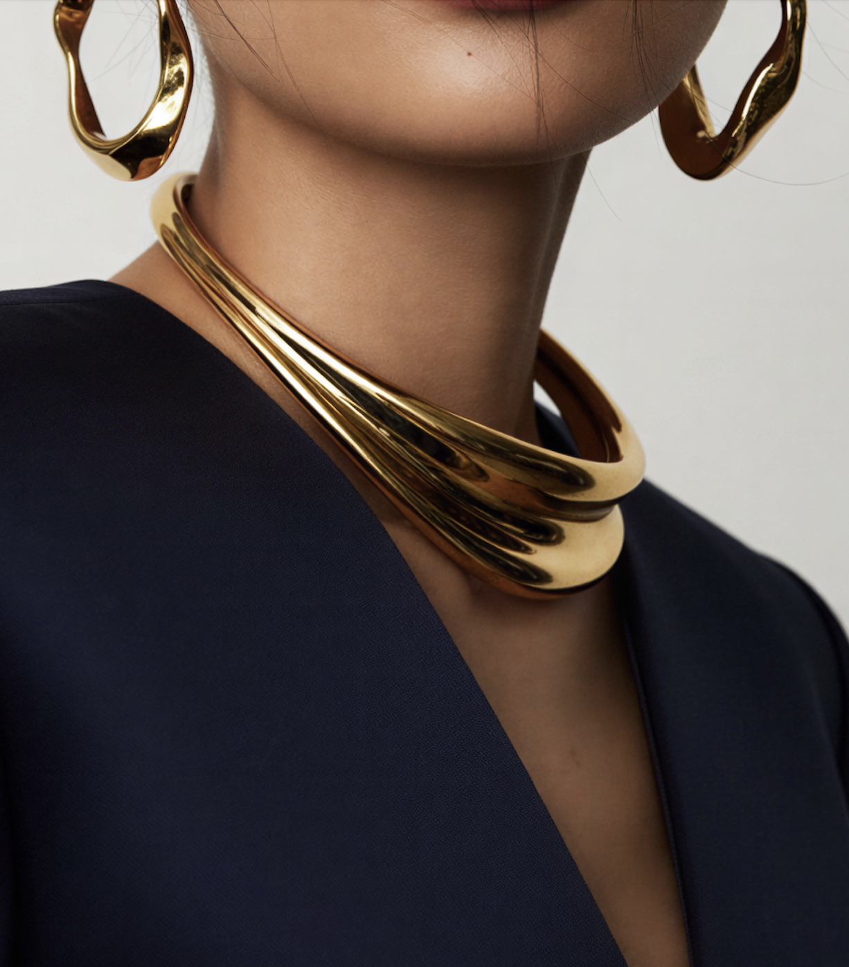 women wearing large gold earrings and necklace