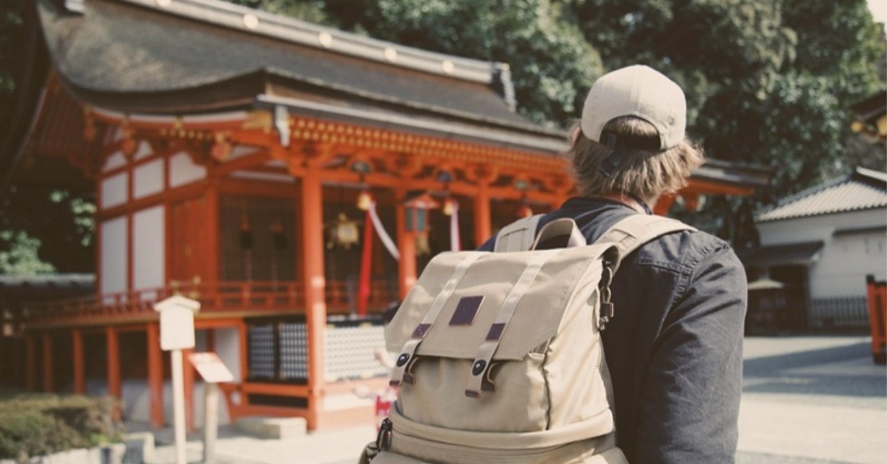 神社を訪れるバックパッカー