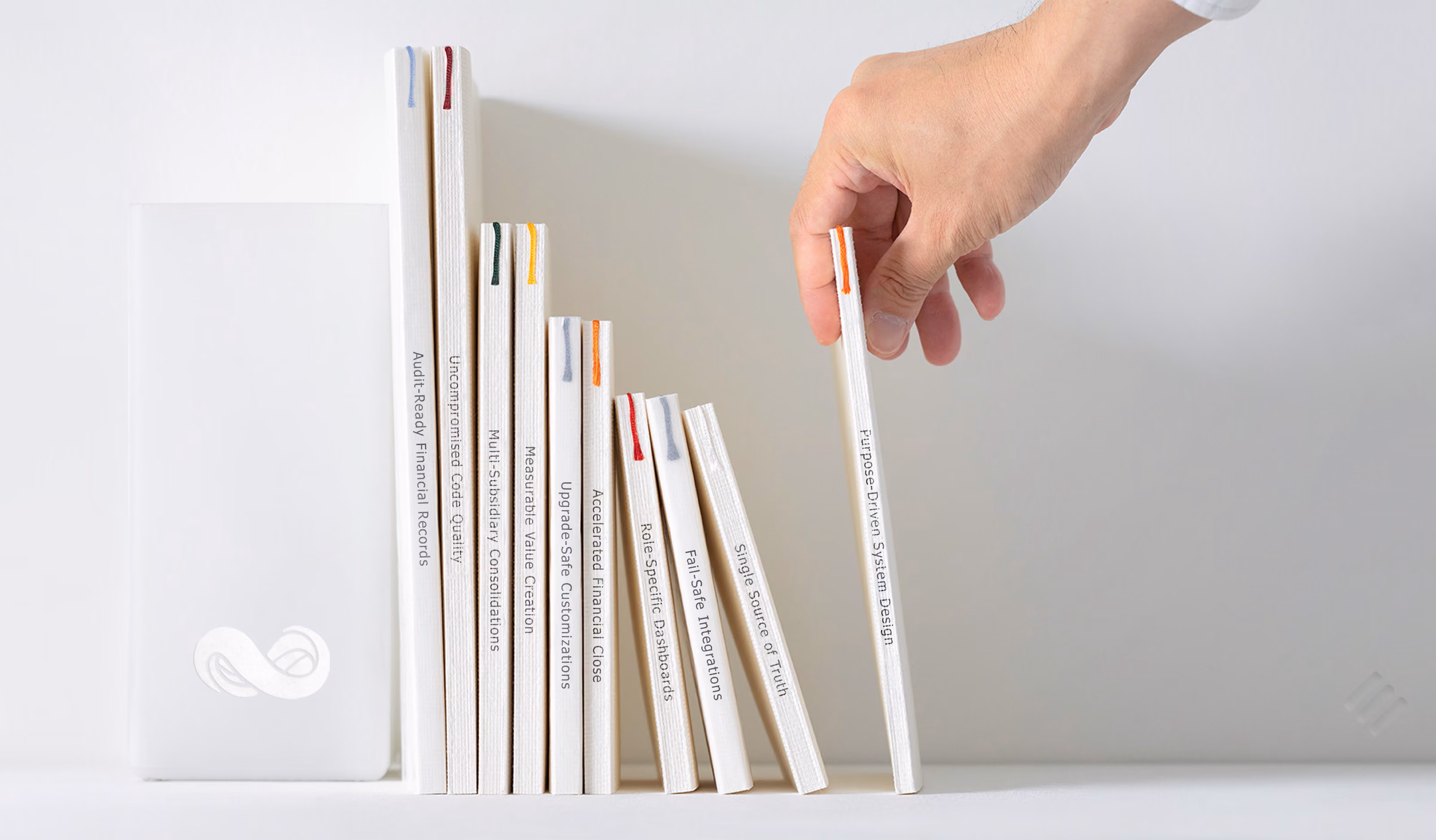 Hand picking up a white book titled Netsuite OneWorld from a row of Netsuite software books on a white shelf.