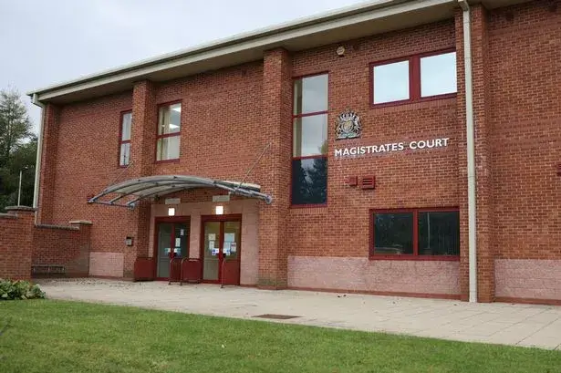 Brick building with red-framed windows and entrance canopy labeled Magistrates Court.