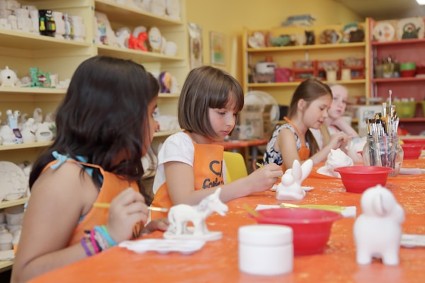 Kids glazing clay figurines.