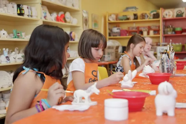 Kids glazing clay figurines.