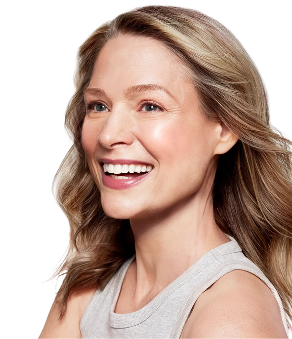 Smiling woman with wavy blonde hair wearing a light gray sleeveless top.