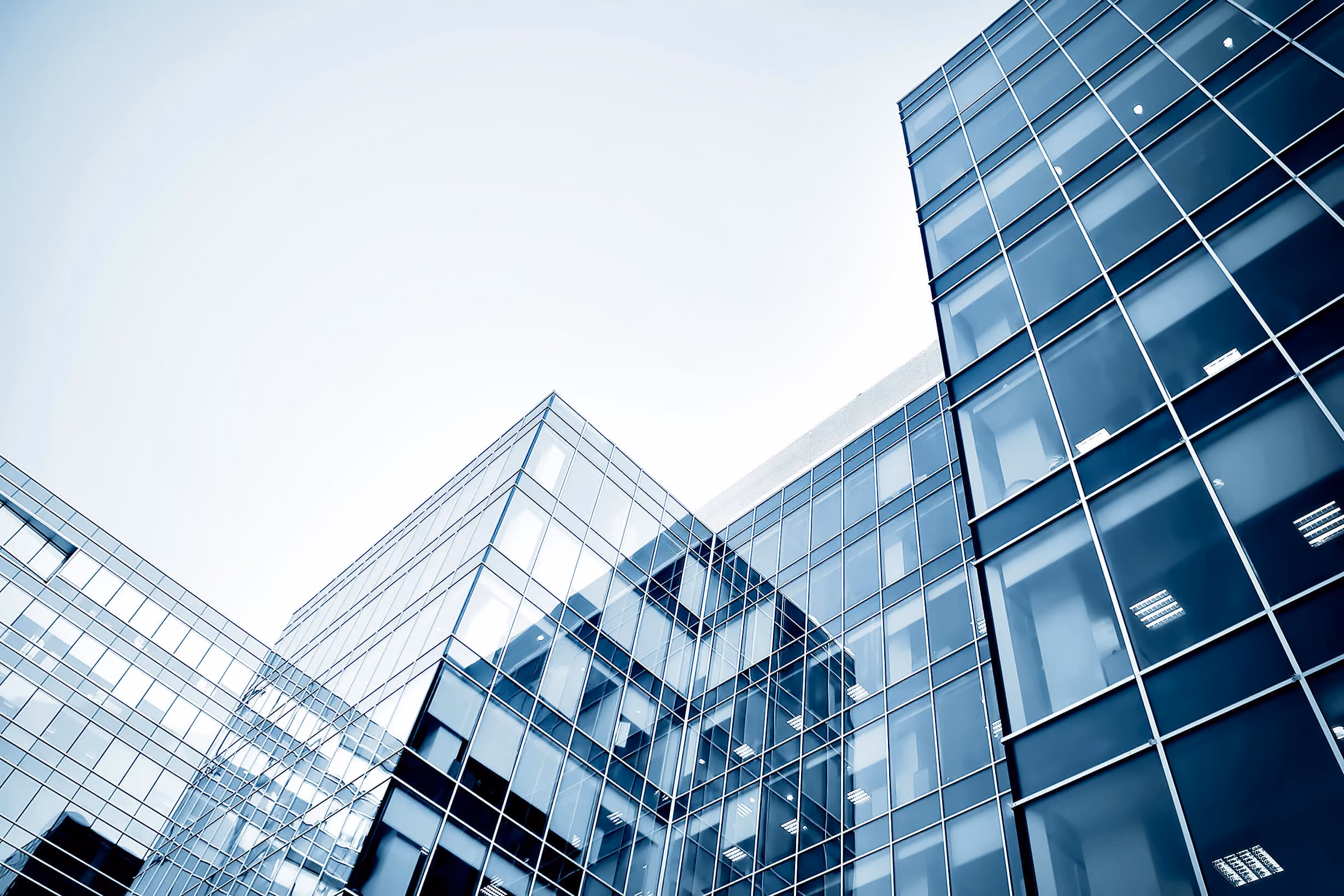 Modern office buildings with reflective glass windows under a clear sky.