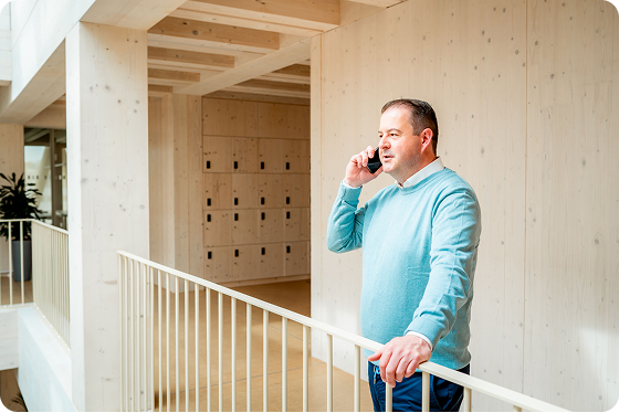 Christian Oberle steht am Geländer und telefoniert.