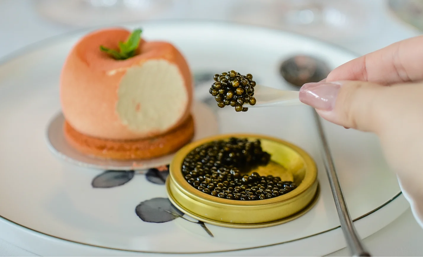 Cucchiaio con caviale premium e lattina dorata aperta su piatto da ristorante