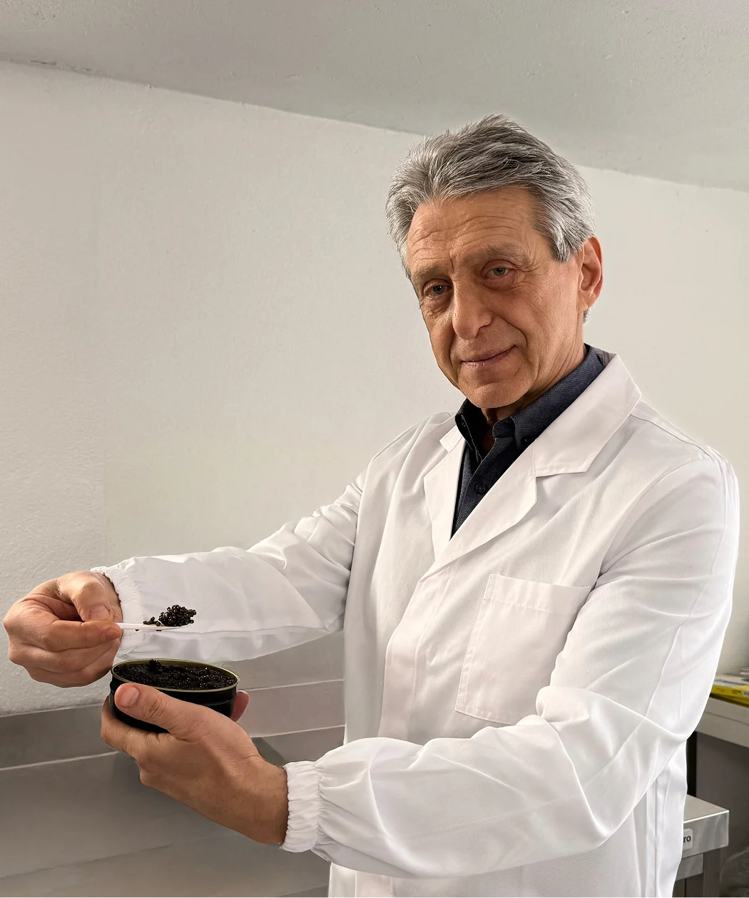 Esperto in camice bianco esamina caviale premium con cucchiaino in laboratorio