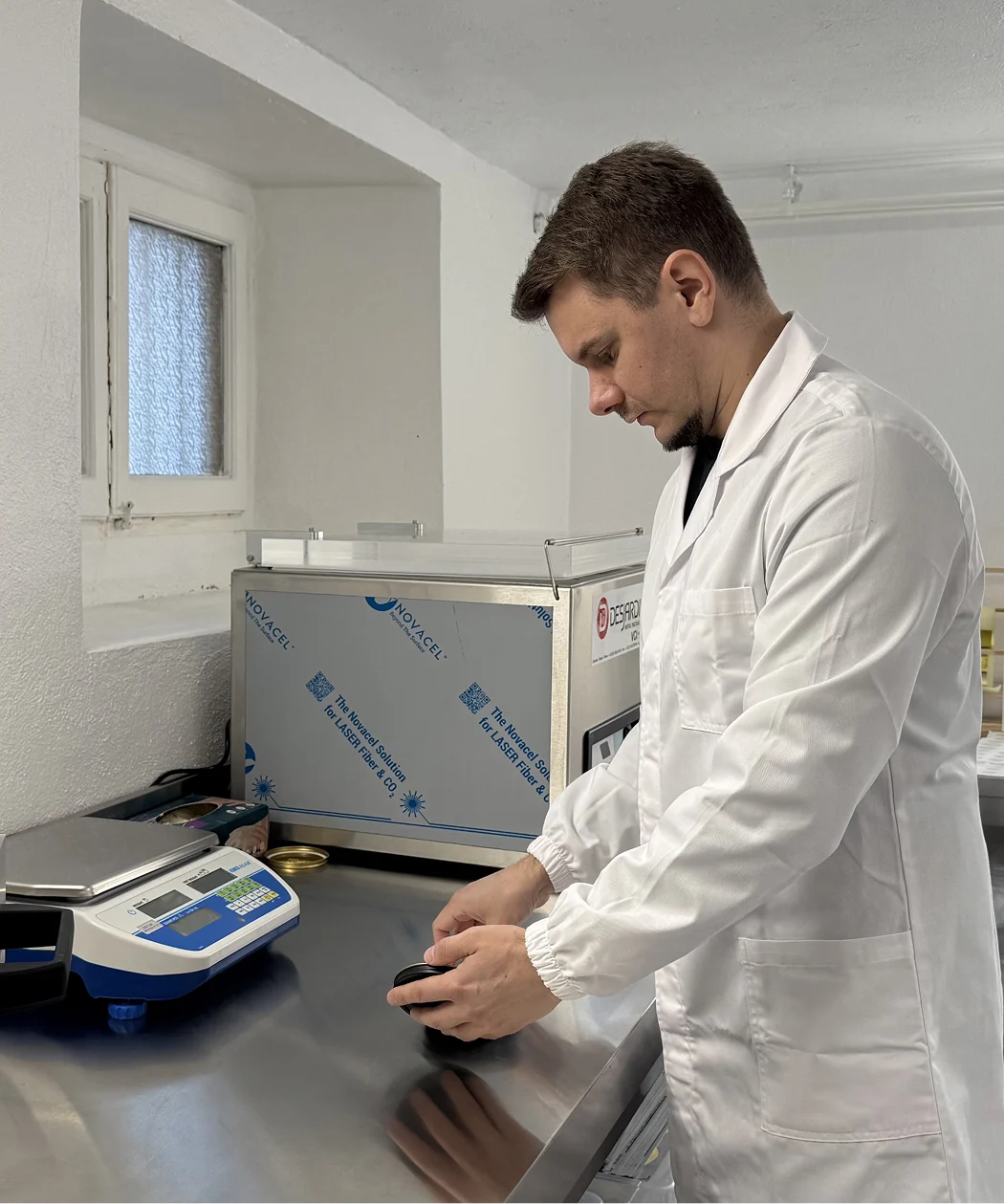 Operatore in camice bianco confeziona caviale premium in laboratorio Nelden Caviar
