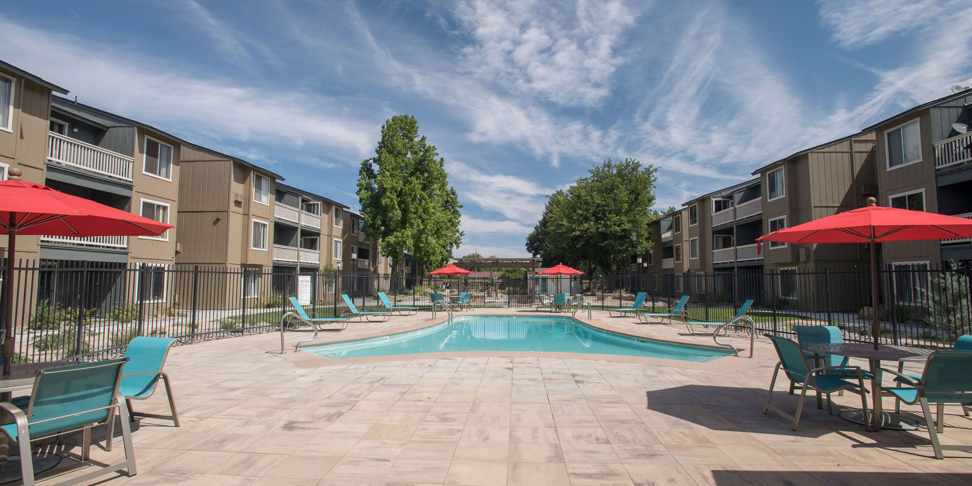 Swimming pool with lounge chairs and tables with umbrellas