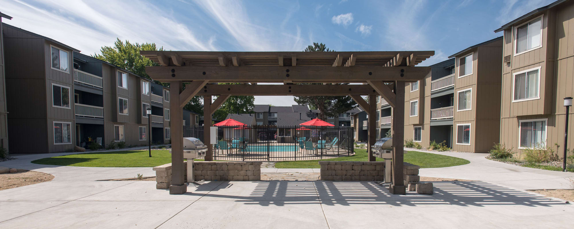 Picnic area with grills under cabana and view of swimming pool