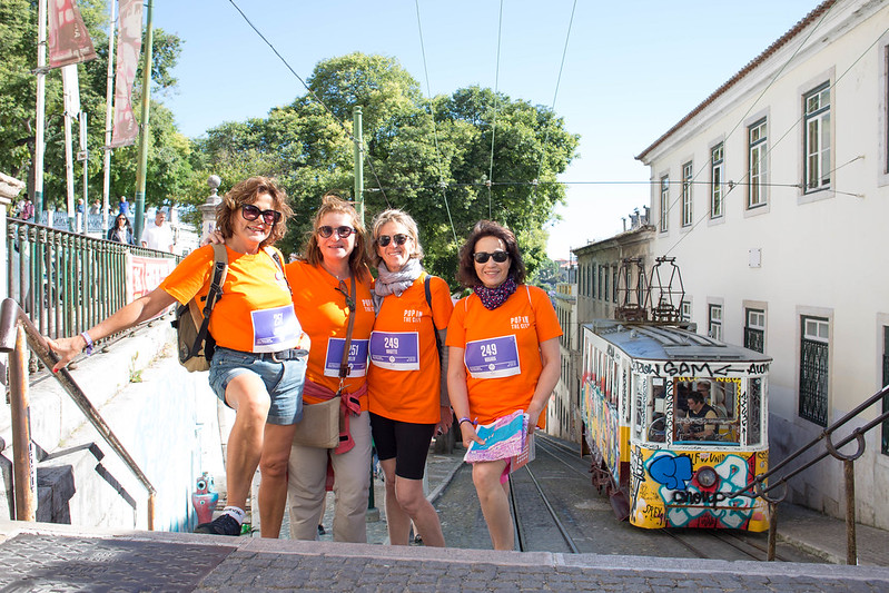 Femmes à Lisbonne qui posent dans une ruelle à côté d'un tramway lors d'un week-end pour découvrir la destination