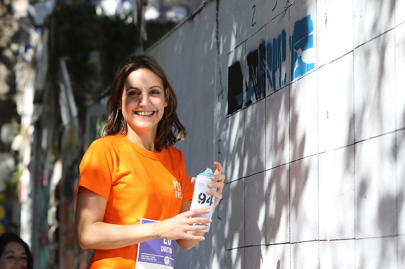 Femme qui s'apprête à graffer un mur lors d'une activité insolite de street-art à Lisbonne.