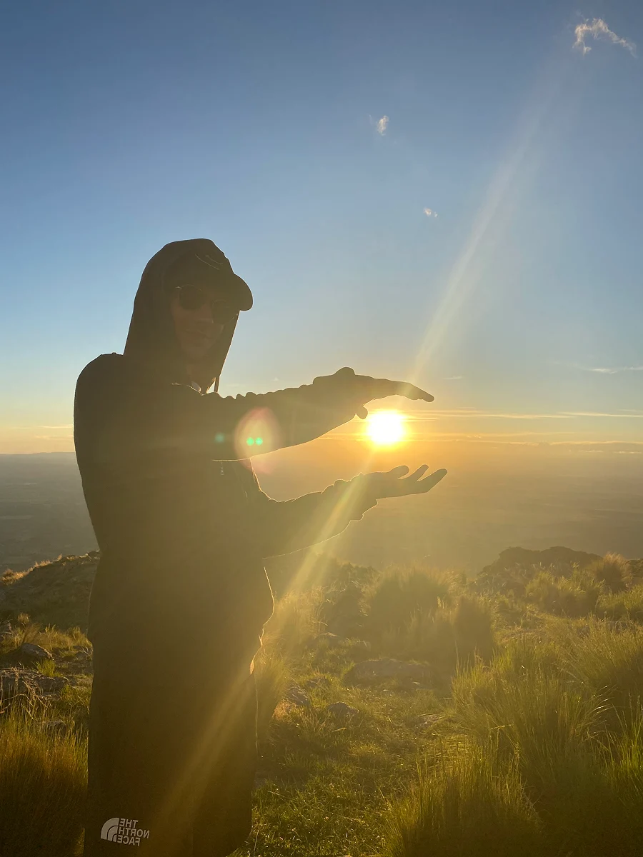 Picture of myself putting my hands around the sun, as the sun sets.