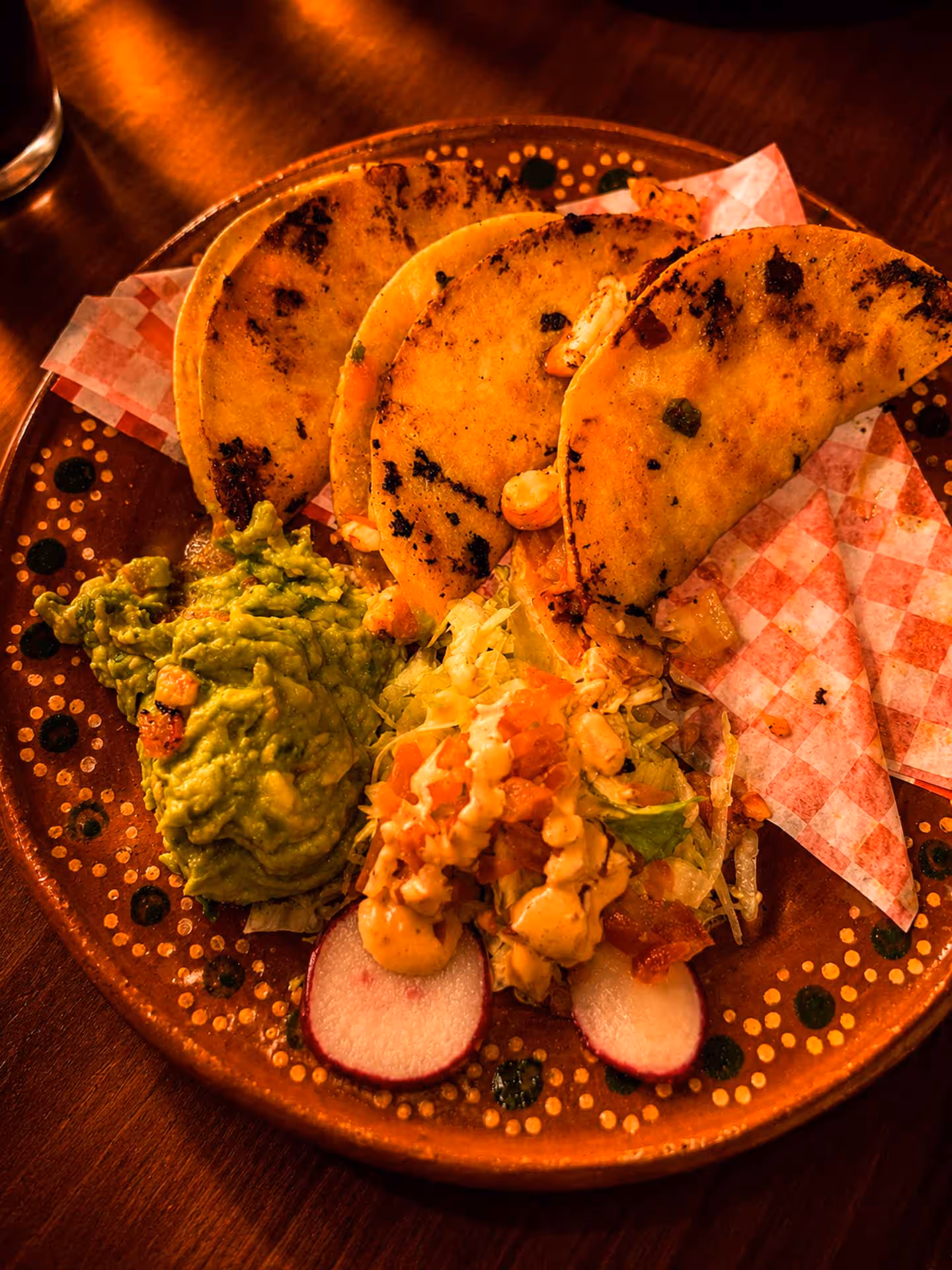 A plate of food with a variety of ingredients including salsa, guacamole, and corn.