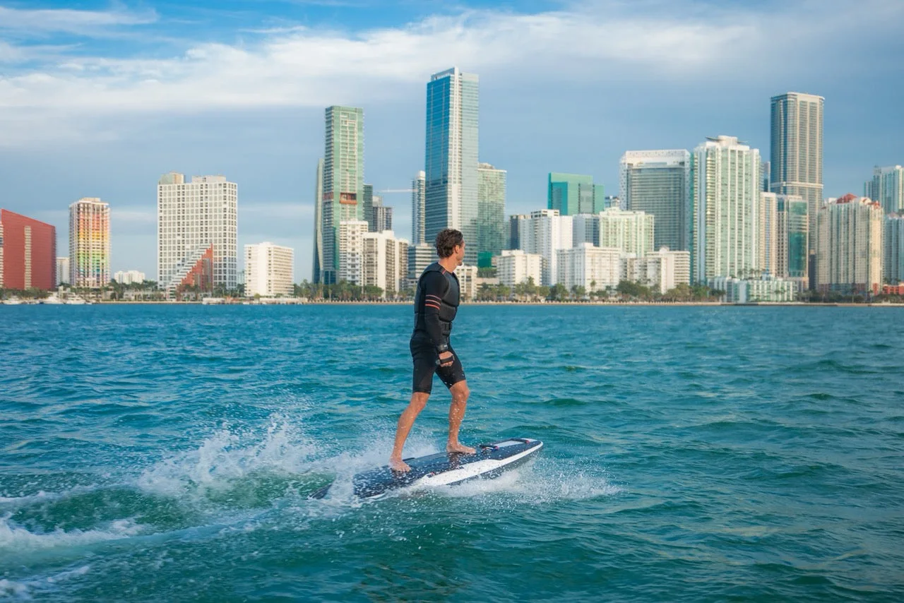 Electric surfboard rider with the Miami skyline behind