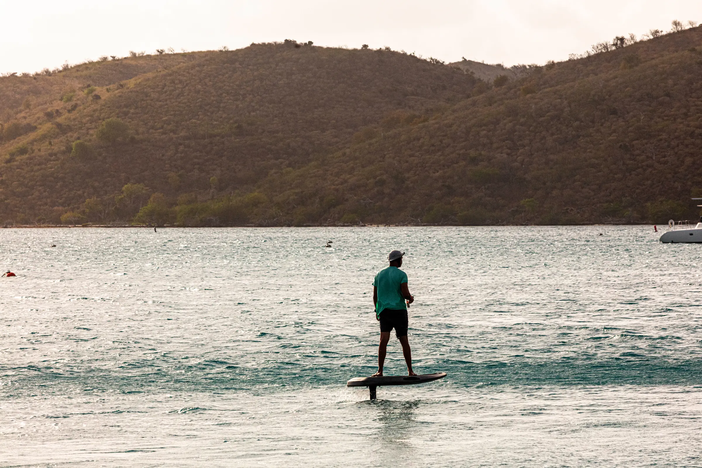 E-Foil rider gliding past an island at golden hour