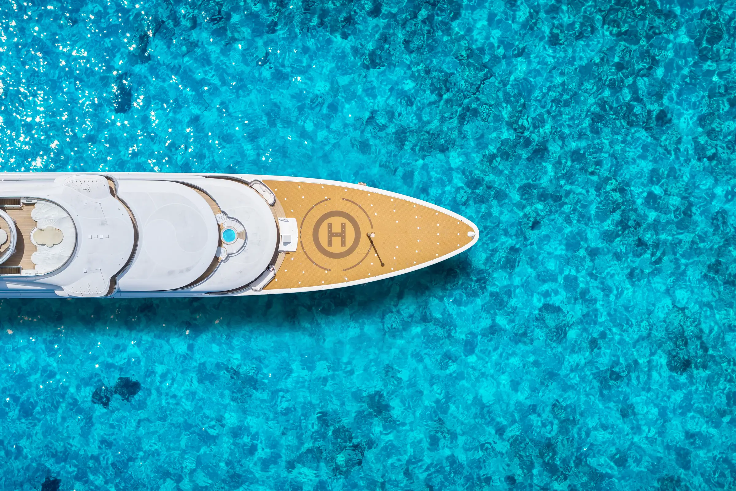 Superyacht seen from above in clear turquoise water