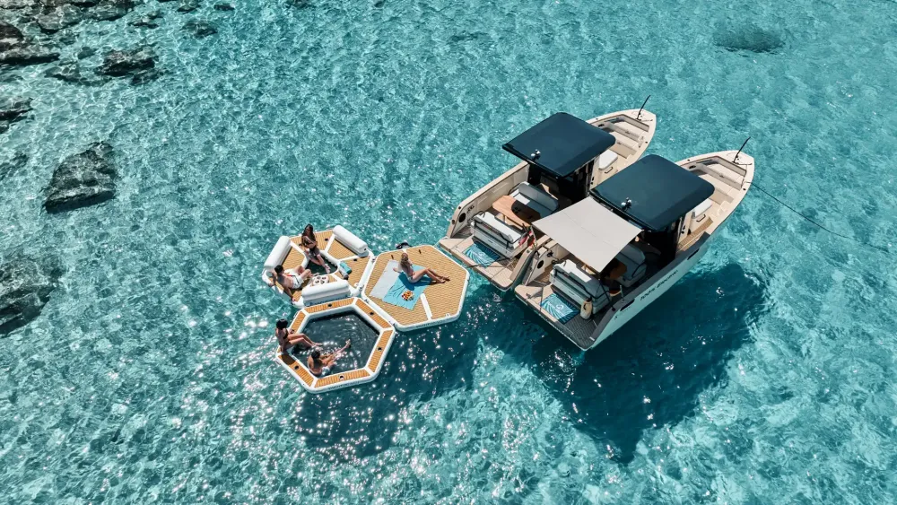 YACHTBEACH Hex platforms linked beside a tender in clear water